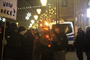 Person mit einer brennenden Fackel auf einer rechten Demonstration.